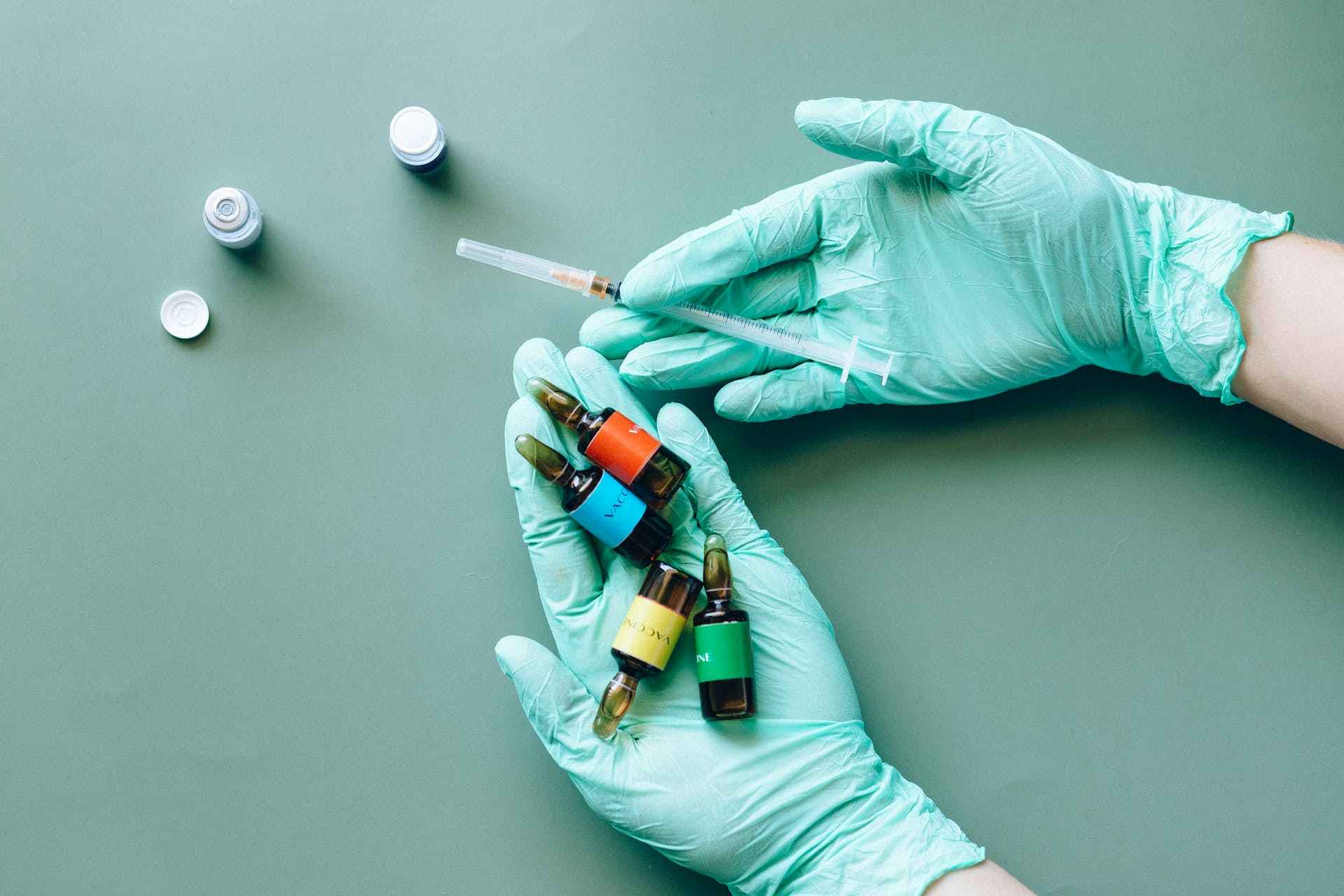 a person with medicine bottles and a syringe on hand